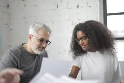 Manager reviewing documents with a new employee during her first weeks on the job