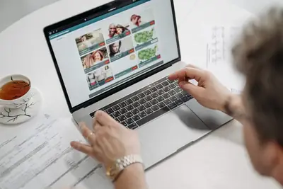 Job seeker browsing a job listings website on a laptop with documents nearby