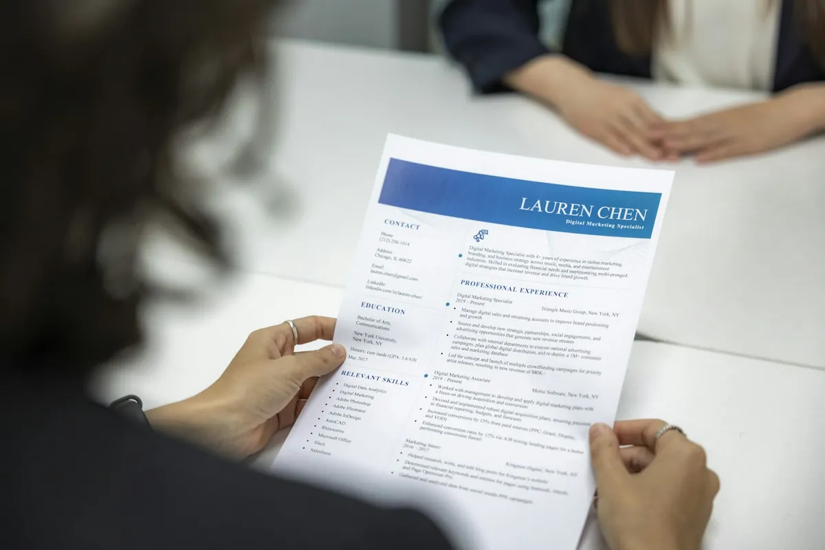 Hiring manager reading a one-page printed resume at a table