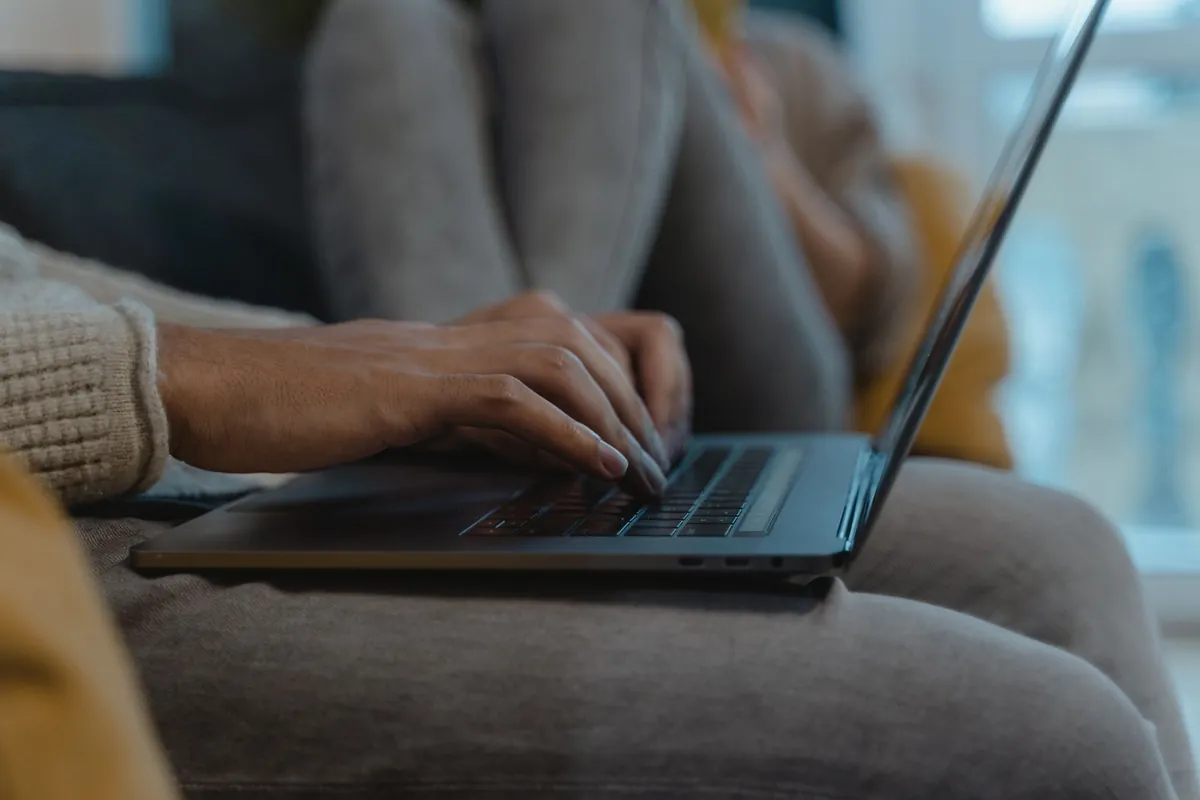 Hands typing an email on a laptop keyboard