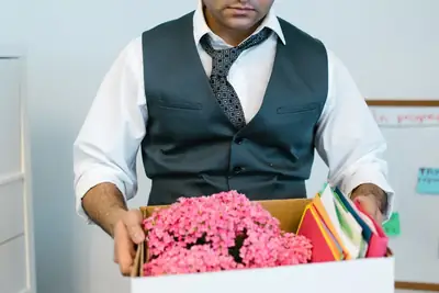 Office worker carrying a box of personal belongings after a layoff